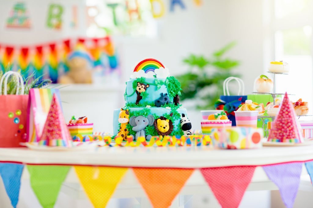 birthday cake table with party supplies